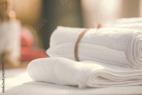 SPA concept: roll of white fluffy bath towels with gblurred background © bundid
