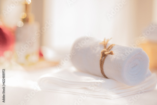 SPA concept: roll of white fluffy bath towels with blurred background