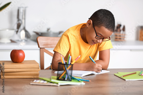 Little African-American boy doing homework in kitchen photo