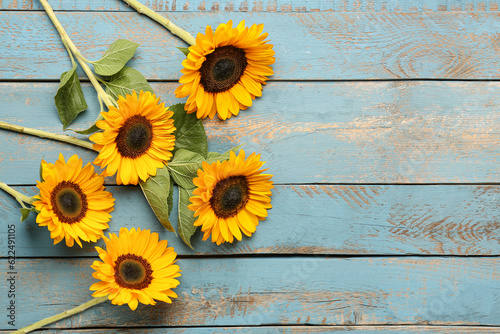 Fototapeta Naklejka Na Ścianę i Meble -  Beautiful sunflowers on blue wooden background