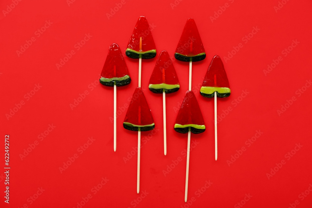 Lollipops in shape of watermelon slice on red background Lollipops in shape of watermelon slice on red background