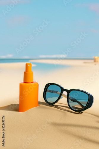 Vintage glasses and sunscreen on the sand beach
