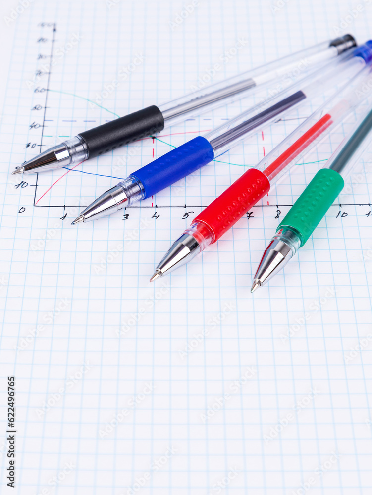 A colorful pens lies on a notebook in a box.. A colorful pens lies on a notebook in a box..
