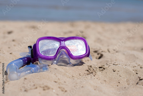 children's diving mask on the sand at the beach