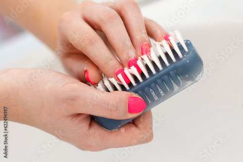 Female washing her hands, using soap brush