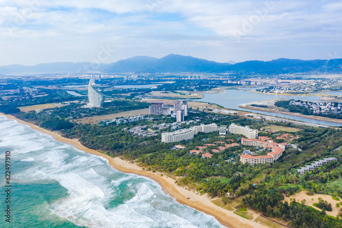 Aerial shots of the waves, coconut groves and cityscape along the coastline of Haitang Bay in Sanya