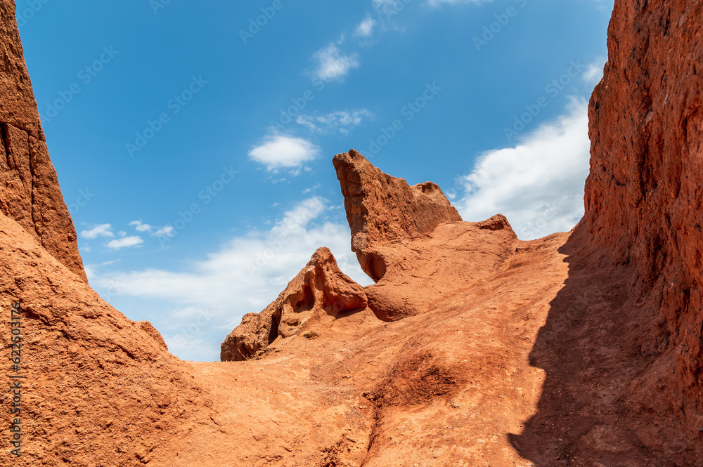Blue sky over red sandy canyons. Amazing geological landscape.