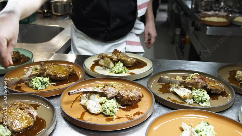 Slow Motion of Chef Added Finishing Touch Garnish on Tomahawk Steak Dishes In Kitchen Slow Motion of Chef Added Finishing Touch Garnish on Tomahawk Steak Dishes In Kitchen