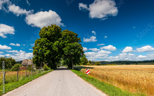 Countryside road among harvested cereals, agricultural landscape with solar p...