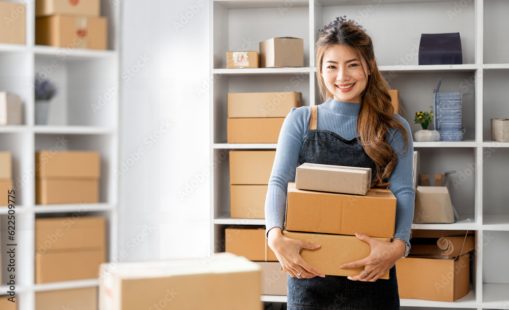 Startup small business entrepreneur or freelance Asian woman holding parcel box, Young success Asian woman with her online marketing packaging box and delivery - obrazy, fototapety, plakaty 