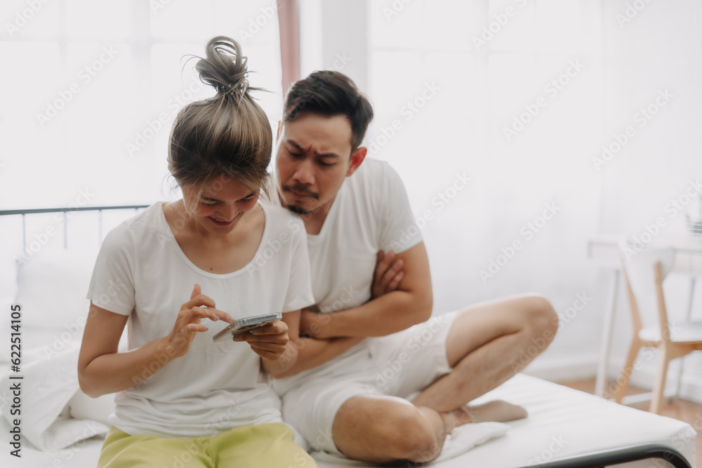 Asian husband peeking wife chatting on the phone if she might has an affair. Asian husband peeking wife chatting on the phone if she might has an affair.