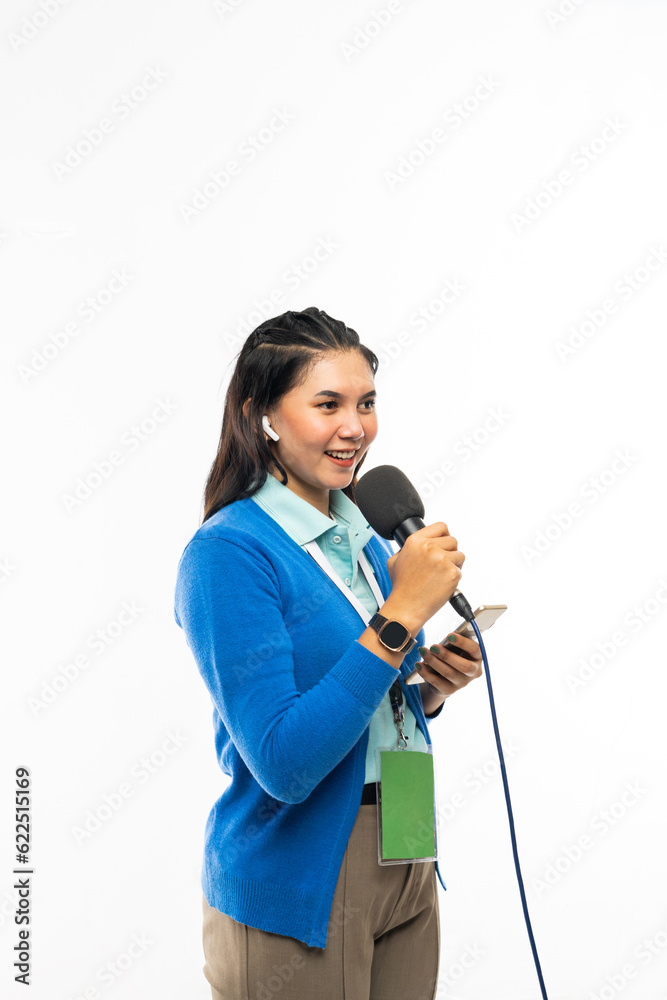 a female reporter in blue shirt and blue cardigan talking using a black microphone at her hand a female reporter in blue shirt and blue cardigan talking using a black microphone at her hand