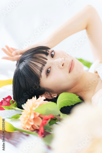 寝そべる女性と花のポートレート 美容 スキンケア コスメ