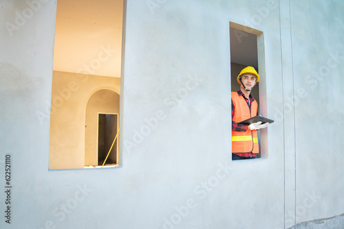 Young engineer in charge of building construction checking his tablet device © Kanyanat