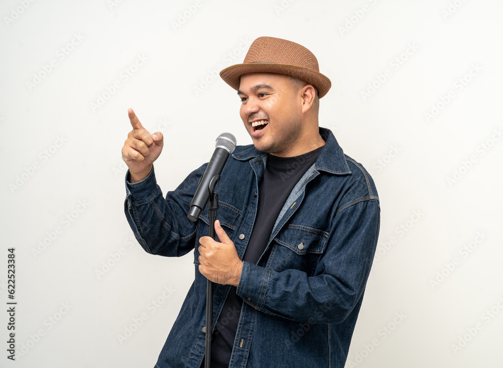 Happiness young asian man singing song. Artist vocalist singer on isolated background. Confident man public speaking talking with microphone in studio. Happiness young asian man singing song. Artist vocalist singer on isolated background. Confident man public speaking talking with microphone in studio.