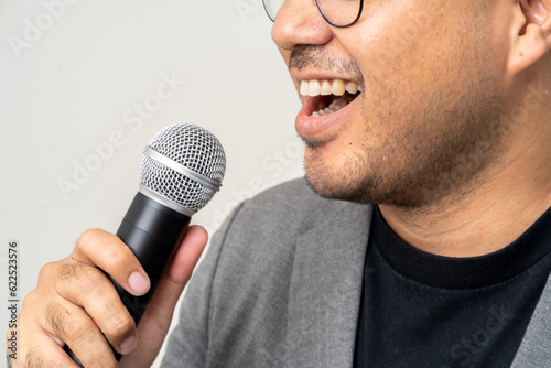 Close up businessman speaker hand holding High quality dynamic microphone and singing song or speaking talking with people on isolated white background. Male testing microphone voice for interview