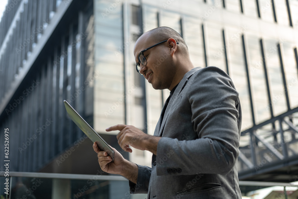 Senior manager business man in suit with tablet at the buildings downtown. Confident man using digital tablet looking towards their goals for success. Executive business man