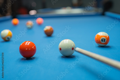 Obraz na plátně billiard stick poking the white ball while starting the billiard game over blue