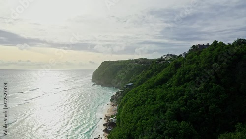 Tropical Island Bali Indonesia drone aerial shot birds eye view landscape nature coastline shore tourist travel Melasti beach sea sunset.