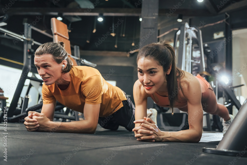 Workout, Fitness workout in gym with trainer assisted in training, Fitness concept, Fit asian woman, Young white man and asian girl exercising in the gym. Workout, Fitness workout in gym with trainer assisted in training, Fitness concept, Fit asian woman, Young white man and asian girl exercising in the gym.