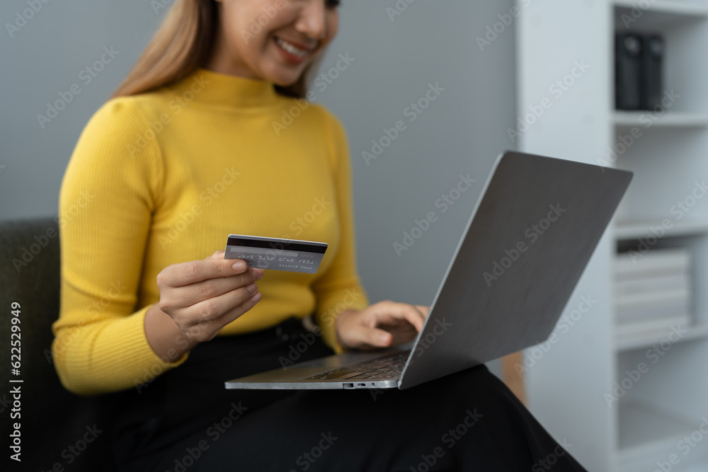 Business woman, young woman holding credit card and using laptop computer for online shopping, e-commerce, banking, internet application, spending money, working from home startup business ideas Business woman, young woman holding credit card and using laptop computer for online shopping, e-commerce, banking, internet application, spending money, working from home startup business ideas