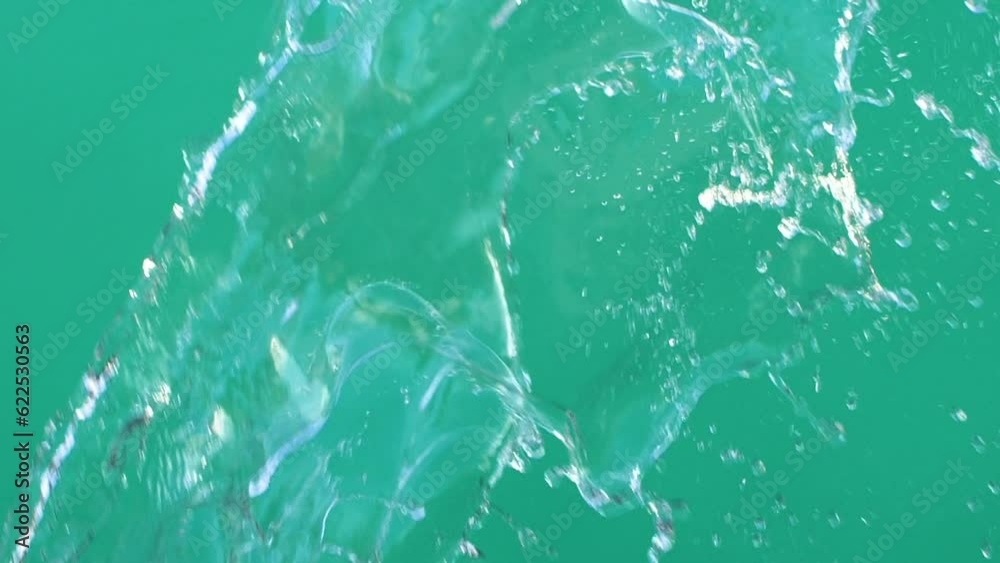 Slow motion of water splashing with drops on green screen chroma key background