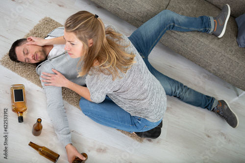 Fototapeta girlfriend trying to wake drunk boyfriend up