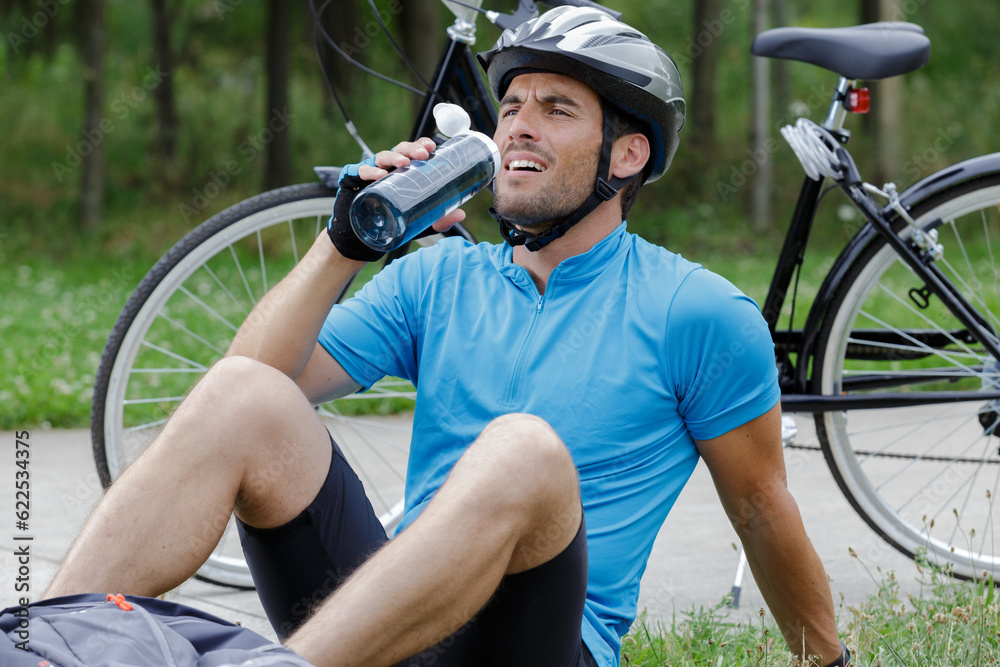Obraz premium male mountain biker drinking water in the forest