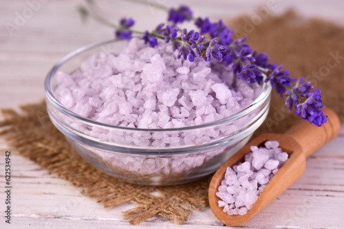 Lavender bath salt in a glass bowl and fresh lavender flowers. 