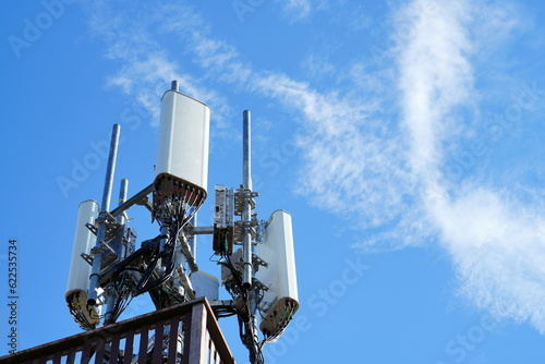 Telecommunication tower of 4G and 5G cellular. Macro Base Station. 5G radio network telecommunication equipment with radio modules and smart antennas mounted on a metal against cloulds sky background. photo