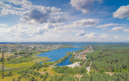 Spring rural landscape in summerю Aerial view. Panoramic view of the village and lake on a sunny day