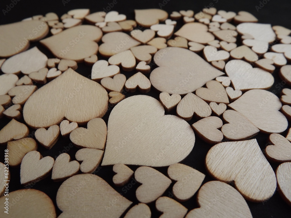 Obraz premium Wooden hearts on a black background as a postcard for the holidays