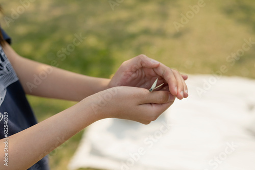 Close-up of a woman's hand holding a butterfly in the park