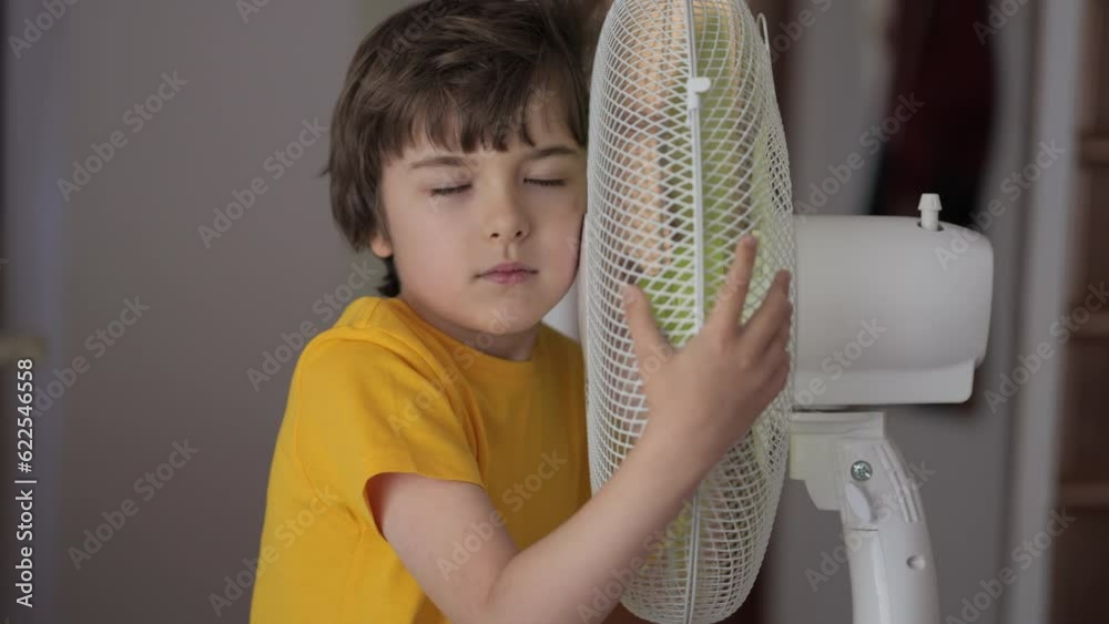 Vidéo Stock Child Enjoying Cool Wind From Electric Fan at Home at Summer Vacation. Boy Suffer