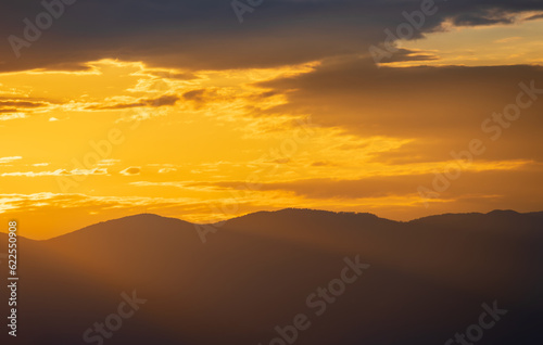 Sunset sky with light beams shine through distant hill. Travel, nature background, Croatia, island Krk