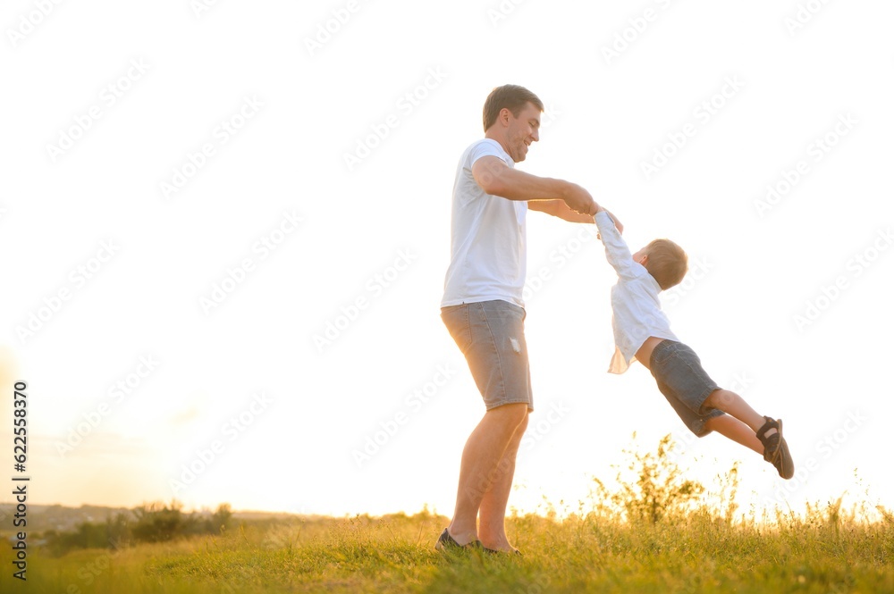 Happy father playing with son on sunset background .The concept of father's day Happy father playing with son on sunset background .The concept of father's day