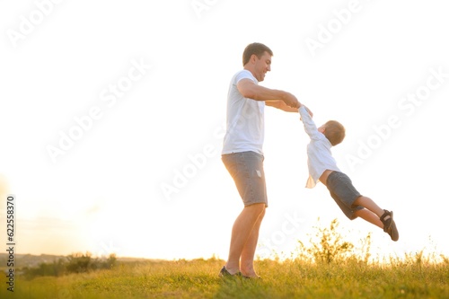 Happy father playing with son on sunset background .The concept of father's day