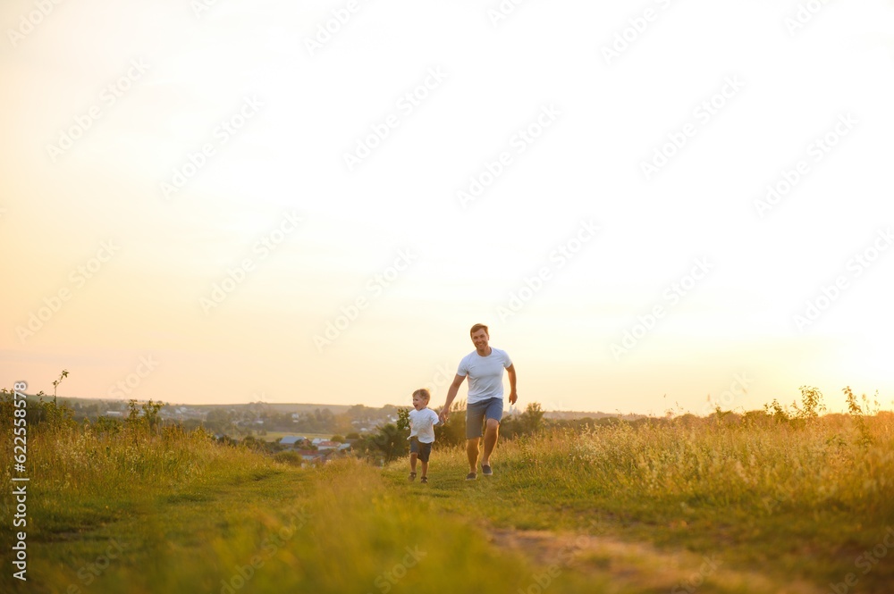 father's day. Dad and son playing together outdoors on a summer. Happy family, father, son at sunset.