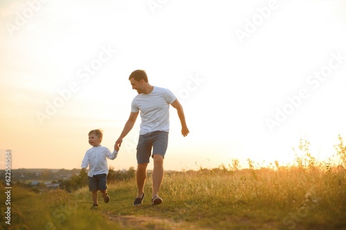 father's day. Dad and son playing together outdoors on a summer. Happy family, father, son at sunset.