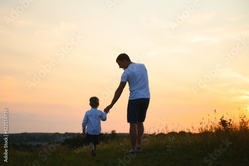 Father's day. Happy family father and toddler son playing and laughing on nature at sunset © Serhii