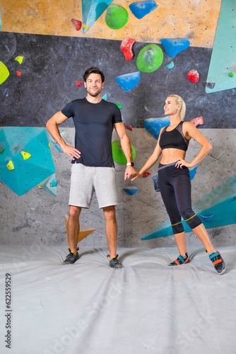 Smiling Caucasian Sport Couple Having good Time While Exercising Before Bouldering Wall Climbing Indoors in Gym.