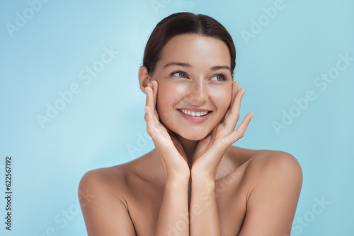 Studio Beauty Care Portrait of Young Adult Woman with Perfect Smile on Blue Background