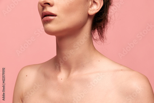 Cropped image of tender naked female body, shoulders and neck against pink studio background. Massage, spa. Concept of female beauty, body care, fitness, sport, health, figure, ad © master1305