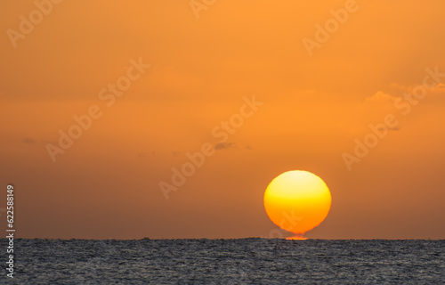 Fototapeta Naklejka Na Ścianę i Meble -  magic sunrise with a burning and torn orange sun at the horizon from the red sea