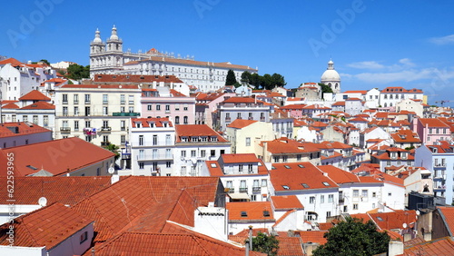 schöner Aussichtspunkt "Miradouro de Santa Luzia" in Lissabon mit weißen Häusern, roten Dächern, Kirchen, Meer und Sonne