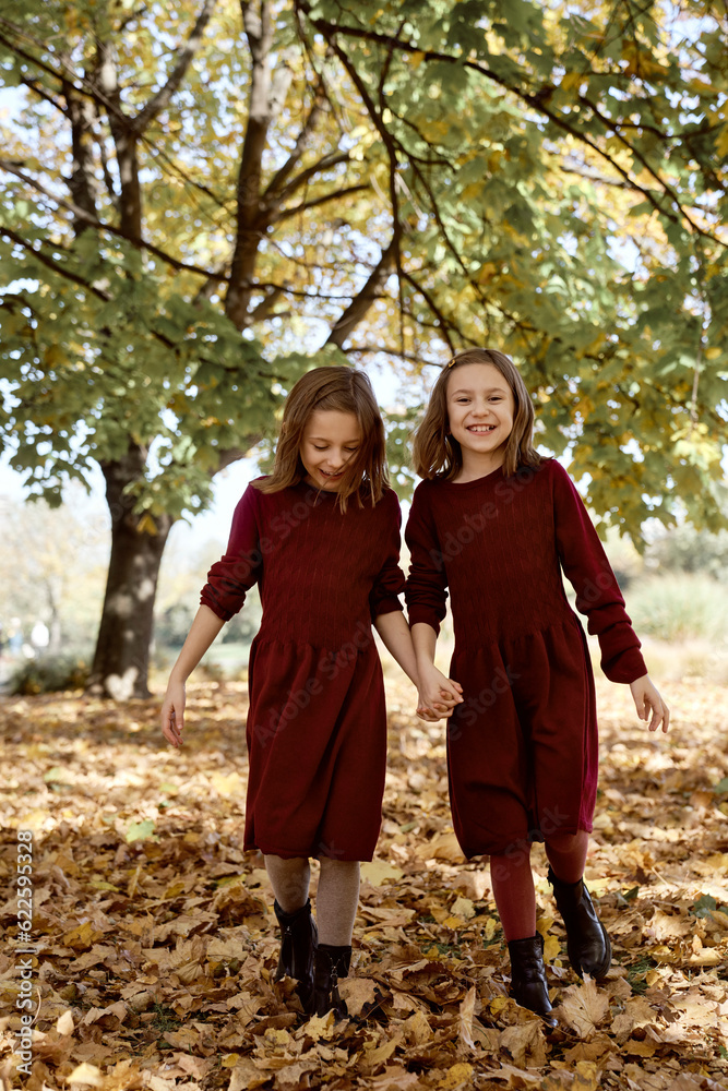 Caucasian twins girls walking together the park