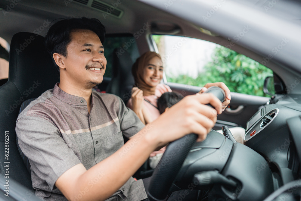 asian muslim family and kid in the car on holiday