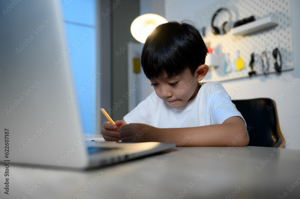 Asian Kid Boy Focused on Homework and Learning Alone in Room at Home, Serious Asian Kid Concentrating on Homework, Studying and Success, Homework and Education of Asian Kids Concept. Asian Kid Boy Focused on Homework and Learning Alone in Room at Home, Serious Asian Kid Concentrating on Homework, Studying and Success, Homework and Education of Asian Kids Concept.
