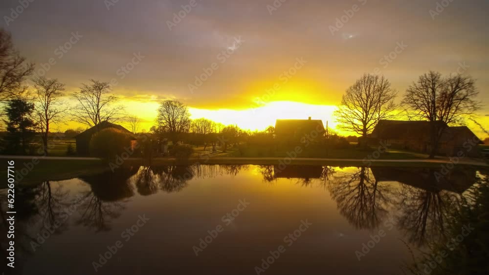 Sunset over a rural setting on a field on the banks of a lake during autumn Sunset over a rural setting on a field on the banks of a lake during autumn