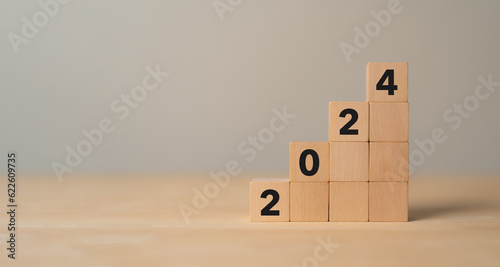 Business growth concept in 2024. Business goals and achievement. Sustainable development. Wooden cubes inscripted 2024 and growth icon on smart background. Positive indicators banner. photo